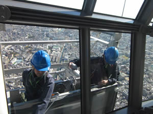 スカイツリー展望回廊の約450メートルの高さから窓拭きにいそしむ男性2人組。