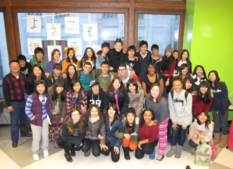 essay-hyogo-4-5 - junglecity.com Group of diverse students posing for a photo in a bright hallway; Japanese'Welcome' signs on the window.