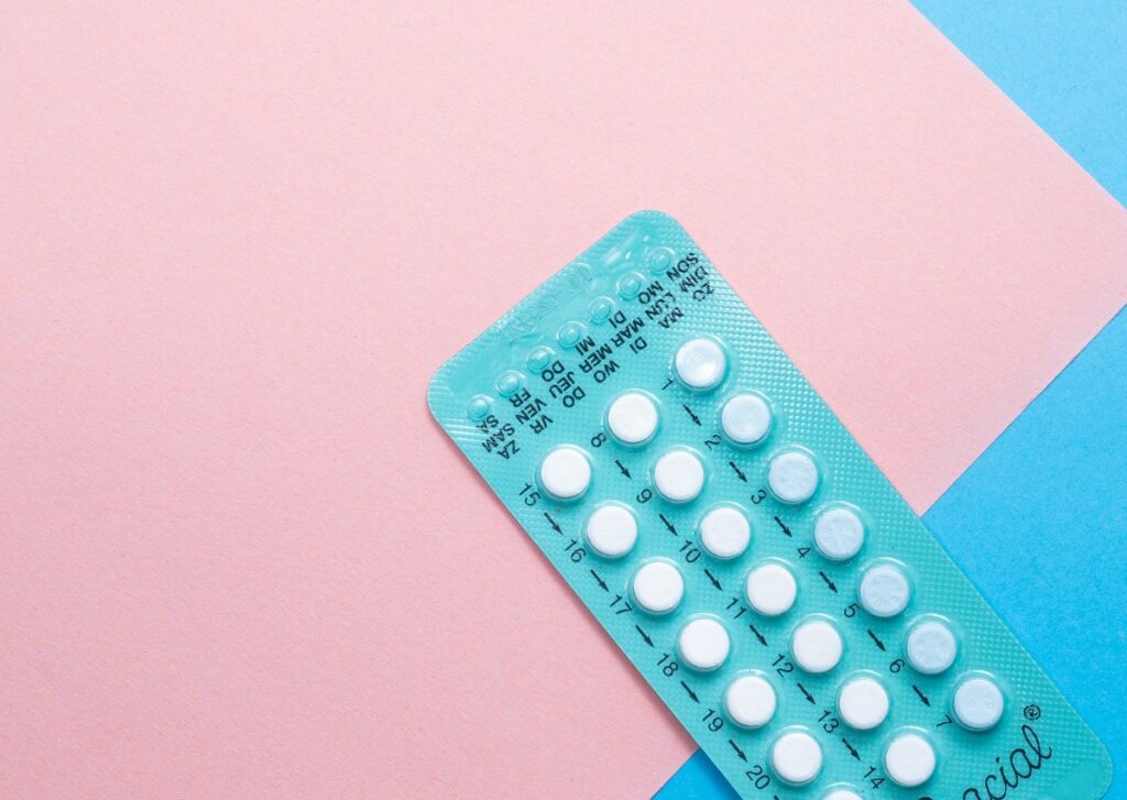 birth-control-6 - junglecity.com Blister pack of white birth control pills on a pastel pink and blue background, diagonally placed.