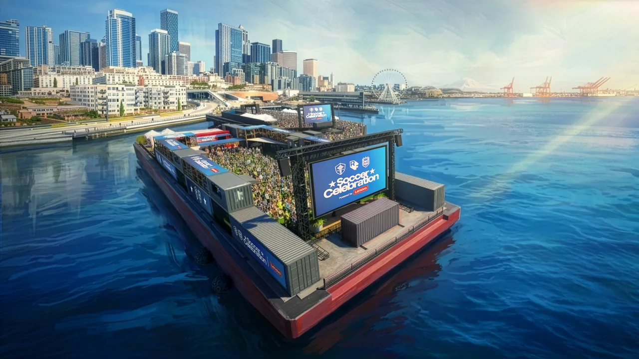 Floating stadium on a red barge hosting a soccer celebration stage over blue water, with a city skyline in the background.