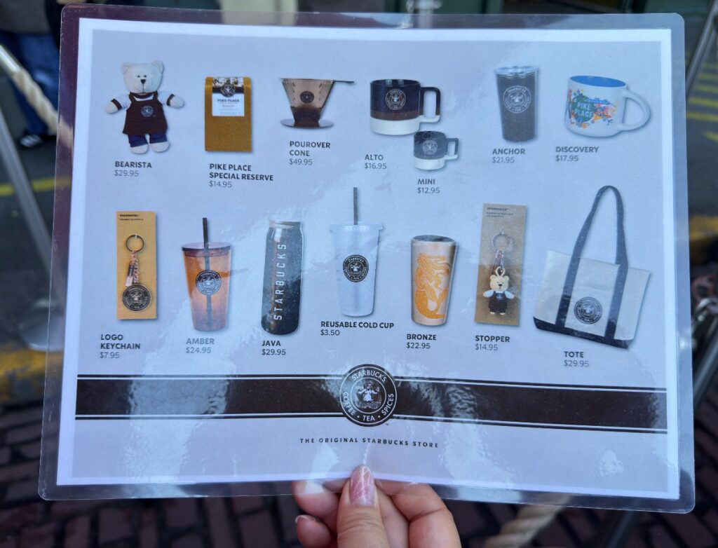 first-starbucks-12 - junglecity.com Shop card showing Starbucks merchandise: plush Bearista, mugs, tumblers, tote bag with prices listed (retail store).