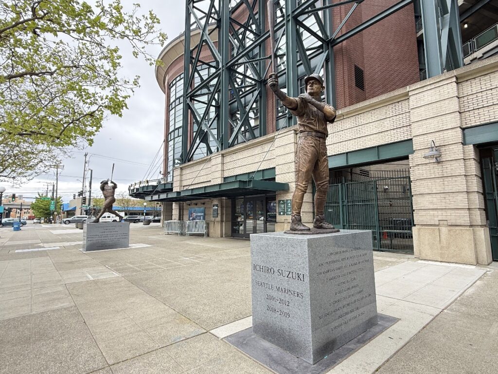 ichiro-statue-4 - junglecity.com Bronze statue of Ichiro Suzuki in Mariners uniform, bat raised, on a granite pedestal outside the stadium entrance.