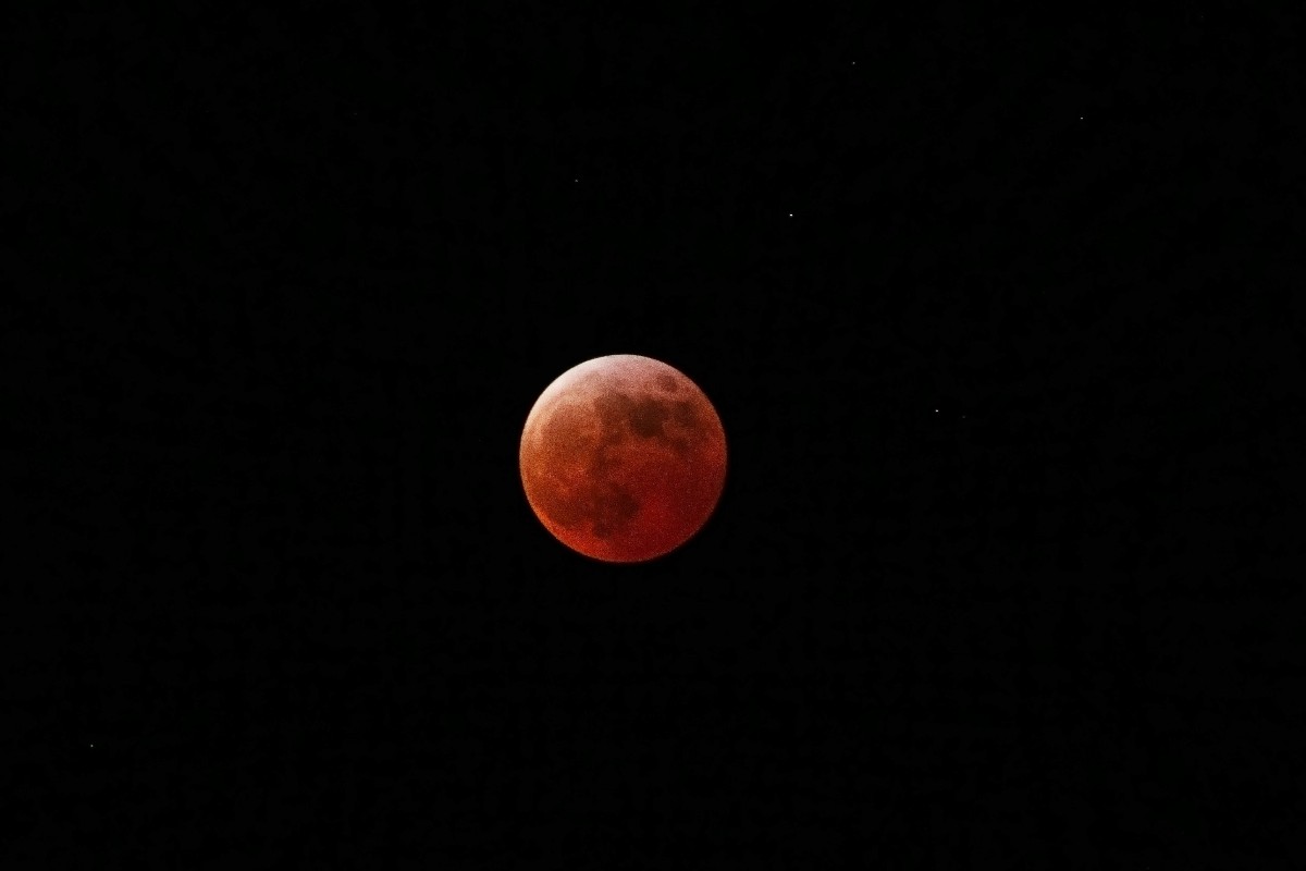 Blood-red Moon during a total lunar eclipse against a dark night sky.