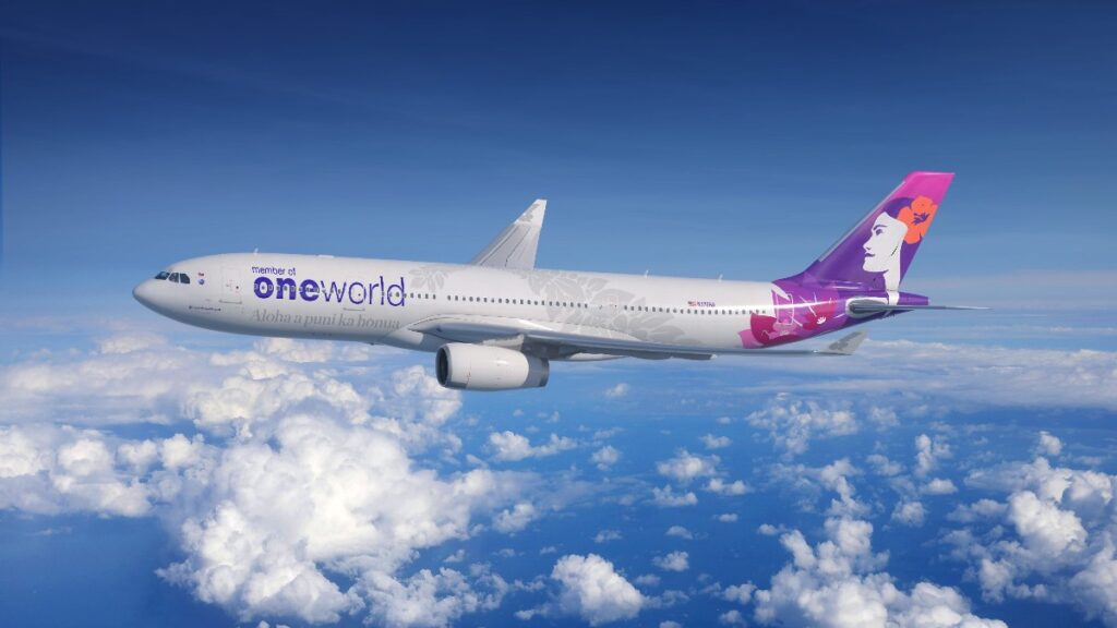 Airliner in flight above clouds with OneWorld branding on the fuselage and a purple tail design.
