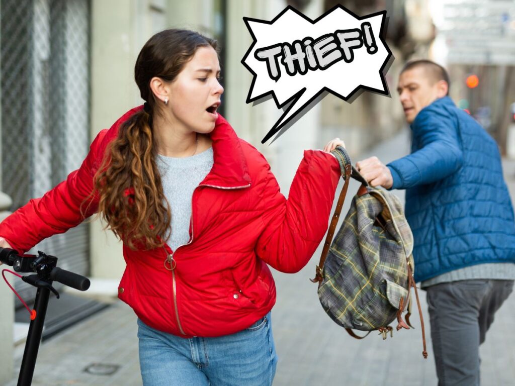 Woman in a red jacket resists as a man grabs her plaid backpack on a city sidewalk; a comic-style THIEF! speech bubble is above them.